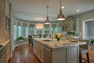 Inspiration for a large transitional l-shaped medium tone wood floor and brown floor eat-in kitchen remodel in Boston with an undermount sink, beaded inset cabinets, gray cabinets, marble countertops, white backsplash, marble backsplash, stainless steel appliances, an island and white countertops
