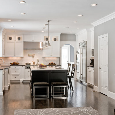 Elegant l-shaped kitchen photo in Boston with stainless steel appliances, a farmhouse sink, white cabinets, white backsplash and subway tile backsplash