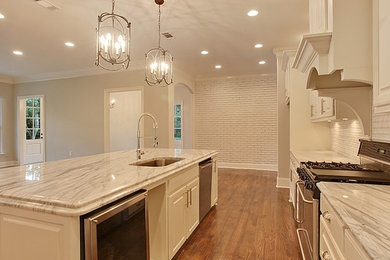 Example of a mid-sized classic galley medium tone wood floor open concept kitchen design in New Orleans with an undermount sink, raised-panel cabinets, white cabinets, marble countertops, beige backsplash, stainless steel appliances and an island