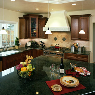 This is an example of a mid-sized traditional l-shaped open plan kitchen in San Francisco with an undermount sink, medium wood cabinets, granite benchtops, beige splashback, stone tile splashback, stainless steel appliances, light hardwood floors, with island and green benchtop.
