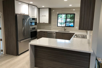 Inspiration for a mid-sized contemporary u-shaped laminate floor eat-in kitchen remodel in San Luis Obispo with an undermount sink, flat-panel cabinets, quartz countertops, beige backsplash, porcelain backsplash, stainless steel appliances, a peninsula and white countertops