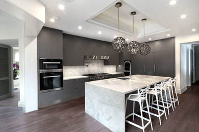 Foto på ett stort funkis grå kök, med en undermonterad diskho, släta luckor, grå skåp, marmorbänkskiva, grått stänkskydd, stänkskydd i marmor, rostfria vitvaror, mörkt trägolv, en köksö och brunt golv