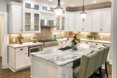 Eat-in kitchen - large traditional u-shaped dark wood floor and brown floor eat-in kitchen idea in Cleveland with a farmhouse sink, shaker cabinets, white cabinets, marble countertops, gray backsplash, glass tile backsplash, stainless steel appliances, an island and multicolored countertops
