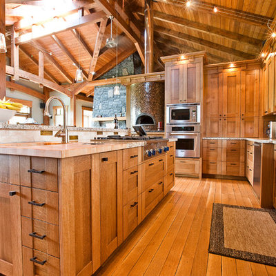 Arts and crafts kitchen photo in Calgary with a farmhouse sink, shaker cabinets, medium tone wood cabinets, wood countertops, multicolored backsplash and stainless steel appliances