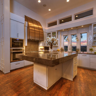 Inspiration for a large transitional u-shaped separate kitchen in Austin with glass-front cabinets, white cabinets, zinc benchtops, stainless steel appliances, dark hardwood floors, with island, white splashback, subway tile splashback, a double-bowl sink, brown floor and brown benchtop.