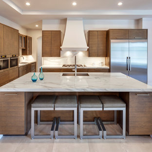 Inspiration for a large contemporary open plan kitchen in Essex with a built-in sink, flat-panel cabinets, medium wood cabinets, marble worktops, white splashback, marble splashback, stainless steel appliances, an island and beige floors.