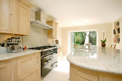 Design ideas for a contemporary kitchen in Surrey with light wood cabinets, marble worktops and an island.