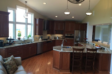 Example of a large l-shaped medium tone wood floor eat-in kitchen design in Baltimore with an undermount sink, shaker cabinets, medium tone wood cabinets, stainless steel appliances and an island