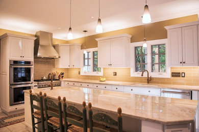 Eat-in kitchen - large transitional l-shaped porcelain tile eat-in kitchen idea in New York with a single-bowl sink, raised-panel cabinets, white cabinets, quartzite countertops, multicolored backsplash, glass tile backsplash, stainless steel appliances and an island