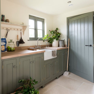 Inspiration for a farmhouse single-wall kitchen in West Midlands with a belfast sink, shaker cabinets, green cabinets, wood worktops and stainless steel appliances.