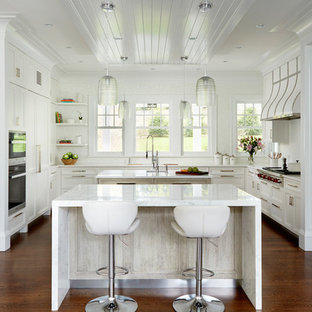 This is an example of a transitional kitchen in New York with flat-panel cabinets, recycled glass benchtops, multiple islands and white benchtop.