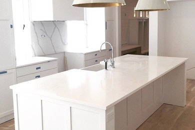 Inspiration for a contemporary galley enclosed kitchen in Bridgeport with a belfast sink, white splashback and an island.