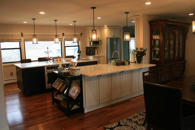 Large transitional galley dark wood floor and brown floor enclosed kitchen photo in New York with an undermount sink, recessed-panel cabinets, white cabinets, quartzite countertops, stainless steel appliances, two islands and white countertops