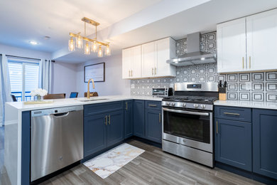Kitchen photo in Philadelphia with white cabinets, multicolored backsplash and white countertops