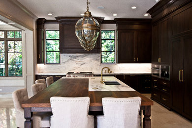 Example of a large transitional l-shaped marble floor and beige floor eat-in kitchen design in Atlanta with an undermount sink, recessed-panel cabinets, dark wood cabinets, marble countertops, gray backsplash, stone slab backsplash, paneled appliances and an island