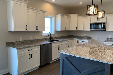 Example of a mid-sized transitional l-shaped eat-in kitchen design in Chicago with gray backsplash, stone slab backsplash, an island and gray countertops