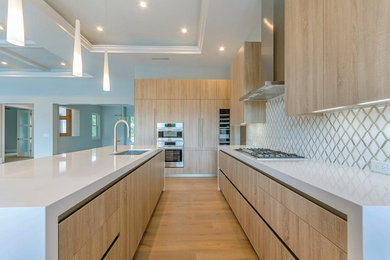 Große, Offene, Zweizeilige Moderne Küche mit Unterbauwaschbecken, flächenbündigen Schrankfronten, Küchengeräten aus Edelstahl, hellem Holzboden, Kücheninsel und hellen Holzschränken in Miami