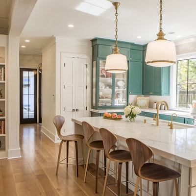 Example of a large transitional u-shaped light wood floor open concept kitchen design in Other with shaker cabinets, green cabinets, quartz countertops, white backsplash, stainless steel appliances and an island