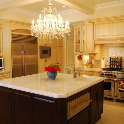 Inspiration for a mediterranean kitchen remodel in Los Angeles with glass-front cabinets, stainless steel appliances, an undermount sink, beige cabinets and white backsplash