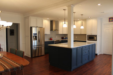 Mid-sized trendy l-shaped dark wood floor and brown floor eat-in kitchen photo in Other with an undermount sink, recessed-panel cabinets, white cabinets, gray backsplash, subway tile backsplash, stainless steel appliances, an island and white countertops