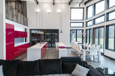 Photo of a large contemporary open plan kitchen in New York with a submerged sink, flat-panel cabinets, red cabinets, engineered stone countertops, grey splashback, matchstick tiled splashback, integrated appliances, porcelain flooring, multiple islands and brown floors.