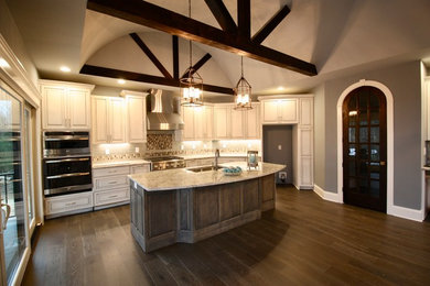 Inspiration for a craftsman dark wood floor and brown floor kitchen remodel in Louisville with a farmhouse sink, raised-panel cabinets, distressed cabinets, granite countertops, blue backsplash, glass tile backsplash and stainless steel appliances