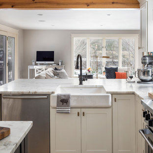 Foto di una grande cucina chic con lavello stile country, ante gialle, top in marmo, paraspruzzi bianco, paraspruzzi in marmo, elettrodomestici in acciaio inossidabile, parquet chiaro, pavimento marrone e top bianco