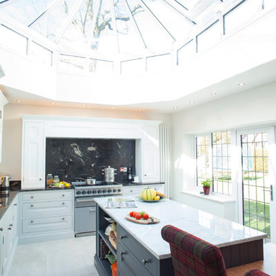 Mid-sized trendy l-shaped ceramic tile eat-in kitchen photo in Essex with recessed-panel cabinets, gray cabinets, black backsplash, stone slab backsplash, stainless steel appliances and an island