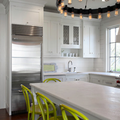 Inspiration for a transitional l-shaped eat-in kitchen remodel in Boston with an undermount sink, shaker cabinets, white cabinets, white backsplash and stainless steel appliances