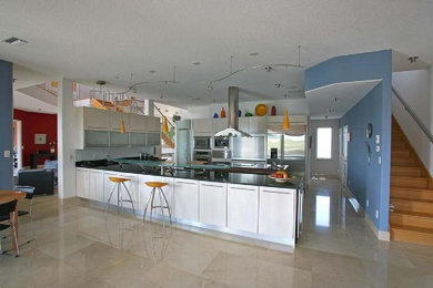 タンパにあるモダンスタイルのおしゃれなキッチン (白いキャビネット、青いキッチンパネル、シルバーの調理設備、アイランドなし) の写真