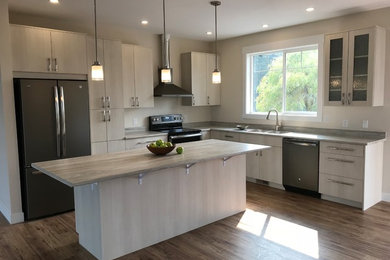 Inspiration for a mid-sized transitional l-shaped open concept kitchen remodel in Vancouver with flat-panel cabinets, light wood cabinets, laminate countertops, an island and beige countertops