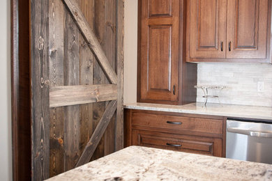 Transitional u-shaped open concept kitchen photo in Minneapolis with an island, raised-panel cabinets, medium tone wood cabinets, granite countertops, beige backsplash, stone tile backsplash and stainless steel appliances