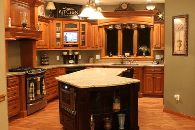 Example of a mid-sized classic l-shaped eat-in kitchen design in Other with raised-panel cabinets, granite countertops, stainless steel appliances, an island, an undermount sink and gray cabinets