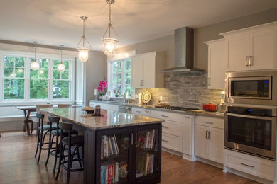 Example of a mid-sized transitional l-shaped medium tone wood floor and brown floor eat-in kitchen design in Philadelphia with an undermount sink, shaker cabinets, white cabinets, granite countertops, gray backsplash, stone tile backsplash, stainless steel appliances, an island and gray countertops