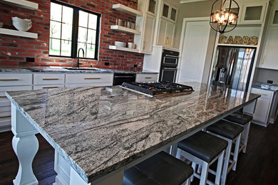 Example of a classic kitchen design in Kansas City with granite countertops and an island