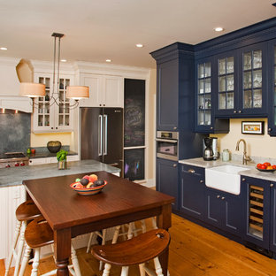 Eat-in kitchen - farmhouse u-shaped eat-in kitchen idea in Philadelphia with a farmhouse sink, glass-front cabinets, blue cabinets, gray backsplash and stainless steel appliances