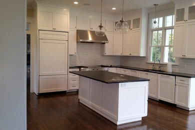 Example of a large minimalist u-shaped dark wood floor and brown floor kitchen design in Richmond with an undermount sink, shaker cabinets, white cabinets, marble countertops, white backsplash, porcelain backsplash, stainless steel appliances and an island