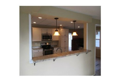 Example of a minimalist galley kitchen design in Baltimore with recessed-panel cabinets and laminate countertops