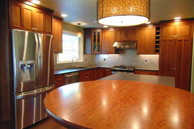 Eat-in kitchen - mid-sized traditional l-shaped dark wood floor and brown floor eat-in kitchen idea in Other with a double-bowl sink, shaker cabinets, dark wood cabinets, soapstone countertops, gray backsplash, stone slab backsplash, stainless steel appliances and two islands