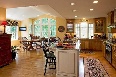 Eat-in kitchen - traditional medium tone wood floor eat-in kitchen idea in Baltimore with an undermount sink, medium tone wood cabinets, granite countertops, stainless steel appliances and an island