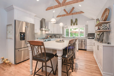 Mid-sized cottage u-shaped brown floor and medium tone wood floor eat-in kitchen photo in Bridgeport with a single-bowl sink, raised-panel cabinets, white cabinets, granite countertops, gray backsplash, ceramic backsplash, stainless steel appliances, an island and white countertops