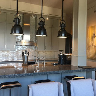 Design ideas for a large industrial l-shaped open plan kitchen in Atlanta with a farmhouse sink, shaker cabinets, grey cabinets, recycled glass benchtops, white splashback, glass tile splashback, stainless steel appliances, with island and beige floor.