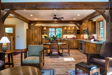 Example of a mid-sized arts and crafts l-shaped light wood floor and beige floor eat-in kitchen design in Other with shaker cabinets, distressed cabinets, granite countertops, stainless steel appliances and no island
