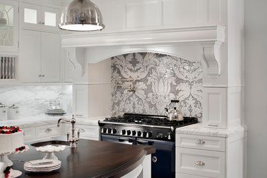 Inspiration for a large transitional u-shaped dark wood floor and black floor kitchen remodel in Boston with an undermount sink, shaker cabinets, white cabinets, marble countertops, gray backsplash, marble backsplash, black appliances and an island