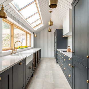 Foto de cocina de galera, tradicional renovada, sin isla, con fregadero sobremueble, encimera de cuarcita, salpicadero blanco, encimeras blancas, armarios estilo shaker, puertas de armario negras y suelo gris