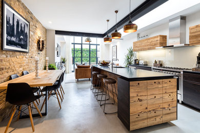 Inspiration for a medium sized industrial kitchen/diner in West Midlands with a submerged sink, flat-panel cabinets, dark wood cabinets, glass sheet splashback, stainless steel appliances, concrete flooring, an island and grey floors.