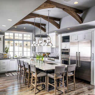 Large transitional u-shaped eat-in kitchen in Other with an undermount sink, marble splashback, with island, shaker cabinets, white cabinets, grey splashback, stainless steel appliances, medium hardwood floors and multi-coloured floor.