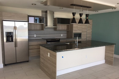 Photo of a medium sized contemporary single-wall kitchen in Tampa with a double-bowl sink, flat-panel cabinets, medium wood cabinets, granite worktops, stainless steel appliances, an island, multi-coloured splashback, porcelain flooring, beige floors and ceramic splashback.