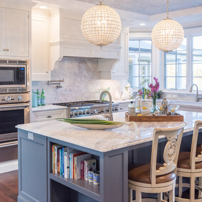 Inspiration for a large timeless u-shaped dark wood floor eat-in kitchen remodel in New York with a farmhouse sink, recessed-panel cabinets, white cabinets, quartzite countertops, gray backsplash, stone slab backsplash, stainless steel appliances and an island
