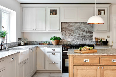 Inredning av ett lantligt stort kök, med en rustik diskho, skåp i shakerstil, grå skåp, granitbänkskiva, flerfärgad stänkskydd, glaspanel som stänkskydd, rostfria vitvaror, klinkergolv i porslin och en köksö